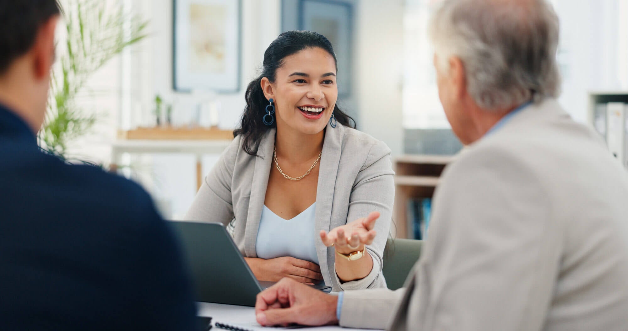 Female account manager meeting with two male clients in an office environment.